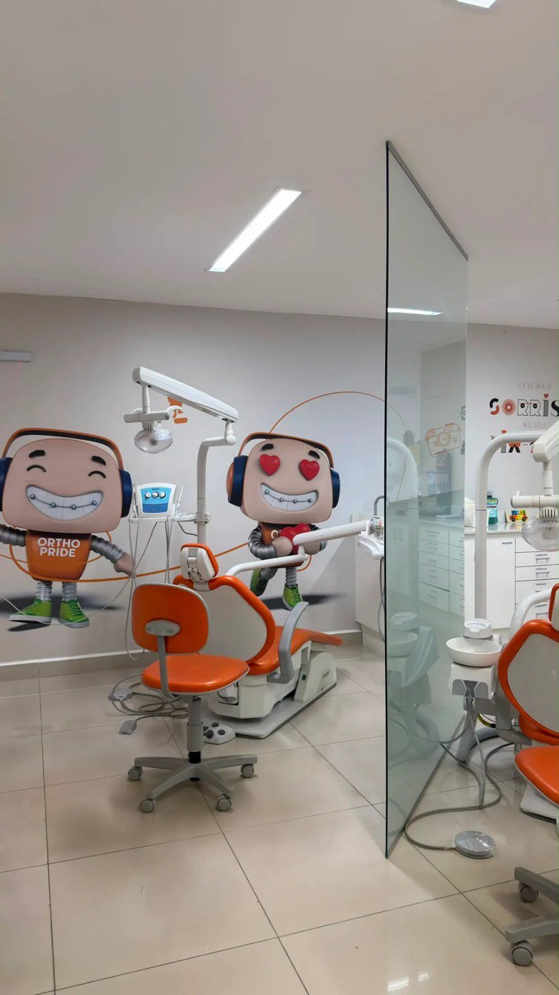 Consultório da Orthopride Itaperuna com painel dos mascotes da marca